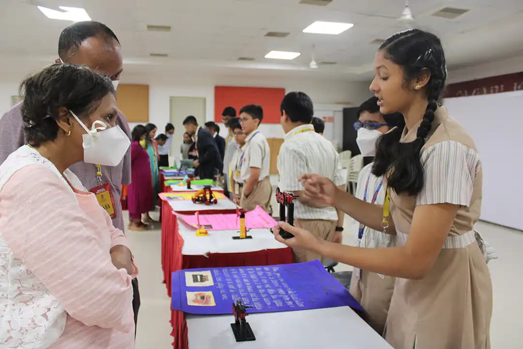 Suchitra student discussing her model with visitors at a makerspace exhibition