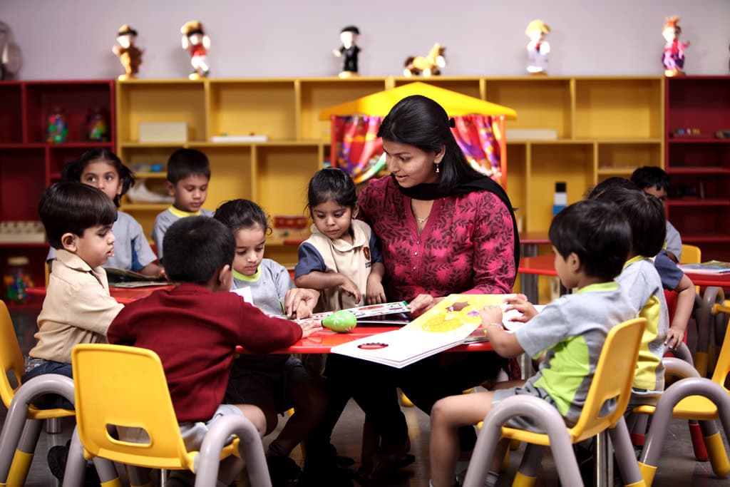 Teacher reading with young learners in a Suchitra classroom